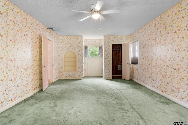 carpeted spare room with a textured ceiling and ceiling fan