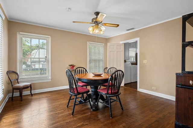 dining area featuring ornamental molding, dark wood-type flooring, ceiling fan, and washer and dryer