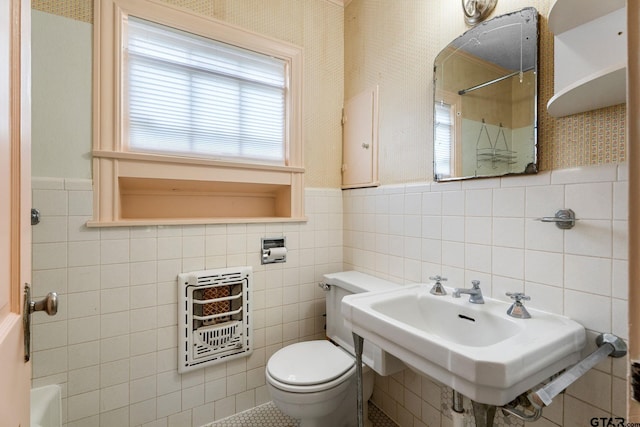 bathroom featuring tile walls, toilet, and heating unit