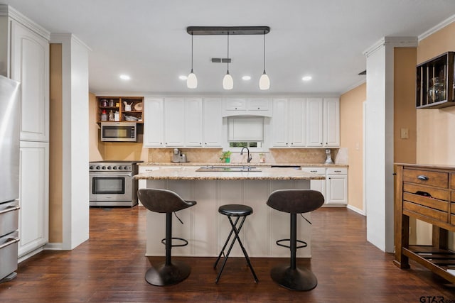 kitchen with a center island, white cabinets, dark hardwood / wood-style floors, light stone countertops, and appliances with stainless steel finishes