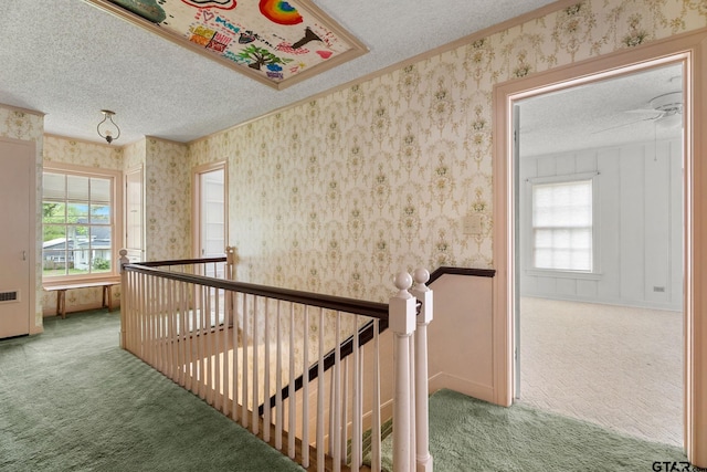 corridor featuring a textured ceiling and carpet flooring