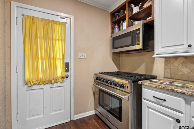 kitchen featuring dark wood-type flooring, decorative backsplash, crown molding, white cabinetry, and appliances with stainless steel finishes