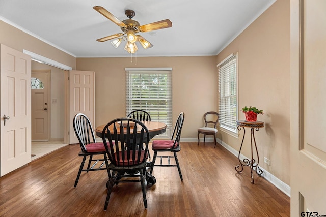 dining area featuring ceiling fan, wood-type flooring, and ornamental molding