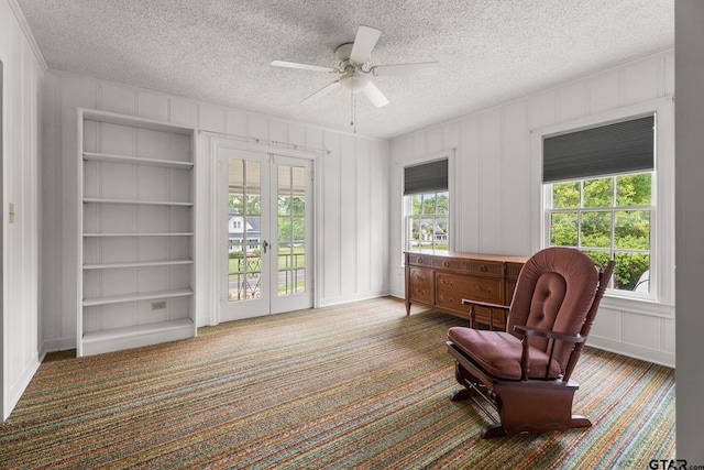 living area with ceiling fan, a healthy amount of sunlight, carpet flooring, and built in shelves