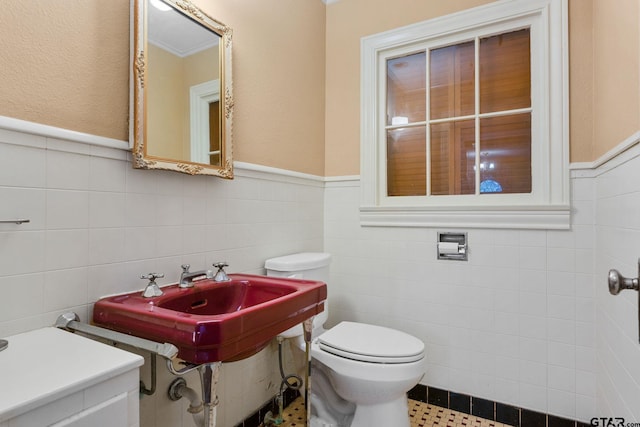 bathroom with toilet and tile walls