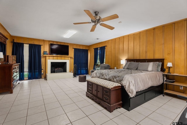 tiled bedroom featuring wood walls and ceiling fan