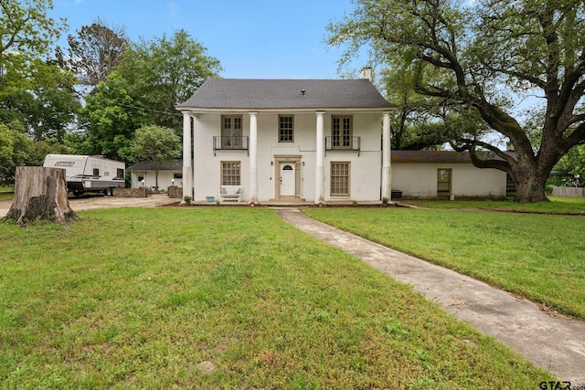 view of front of house with a front yard and a balcony