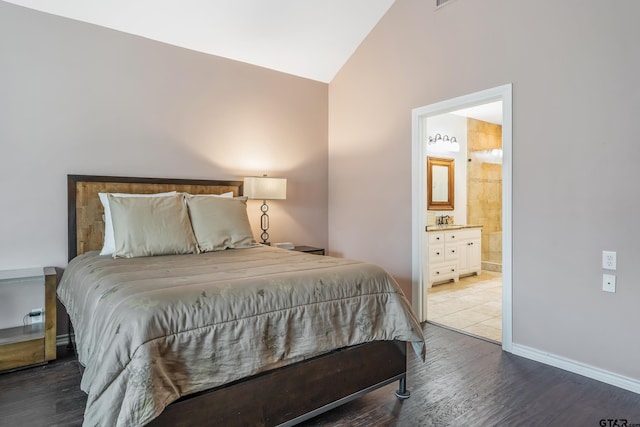 bedroom with sink, lofted ceiling, connected bathroom, and wood-type flooring