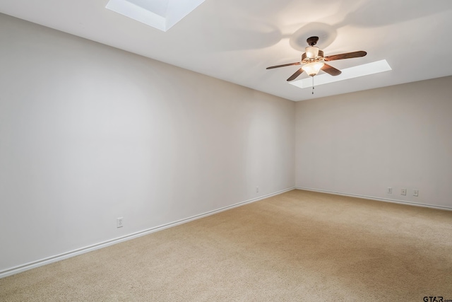 carpeted empty room with ceiling fan and a skylight