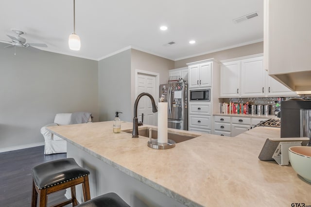 kitchen featuring built in microwave, white cabinets, decorative light fixtures, stainless steel refrigerator, and ornamental molding