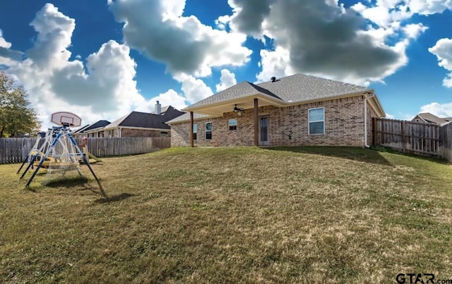 rear view of house with a playground and a lawn