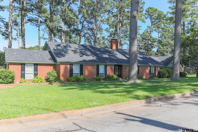 8310 Columbia Dr, Tyler, TX 75703 - single story home featuring a chimney, brick siding, a front lawn, and roof with shingles