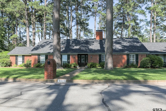 8310 Columbia Dr, Tyler, TX 75703 - view of front of property featuring brick siding, a chimney, a front lawn, and a shingled roof