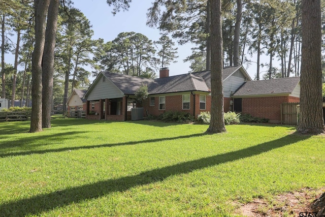 8310 Columbia Dr, Tyler, TX 75703 - rear view of property with a yard, brick siding, and a chimney