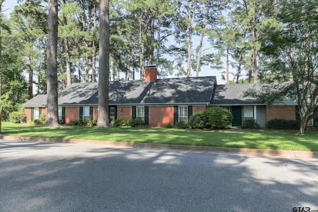 8310 Columbia Dr, Tyler, TX 75703 - ranch-style home featuring brick siding, a chimney, and a front lawn