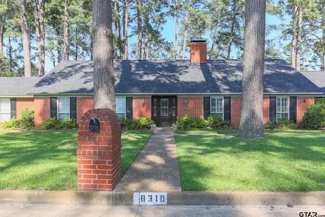 8310 Columbia Dr, Tyler, TX 75703 - cape cod-style house featuring brick siding, a front yard, a chimney, and roof with shingles
