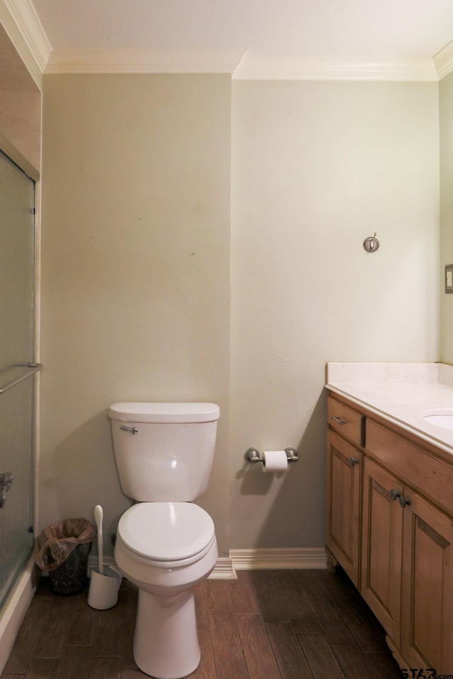8310 Columbia Dr, Tyler, TX 75703 - full bathroom featuring crown molding, a stall shower, vanity, wood finished floors, and toilet