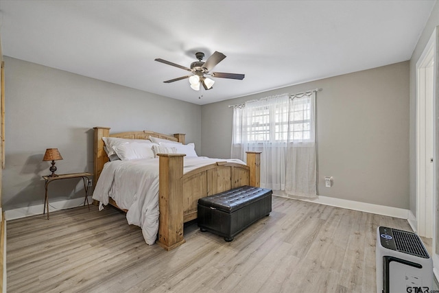 bedroom with light hardwood / wood-style flooring, heating unit, and ceiling fan