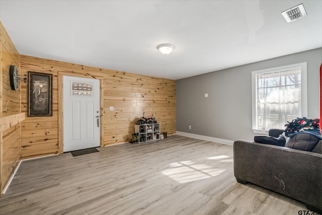 living room with wood walls and light hardwood / wood-style floors