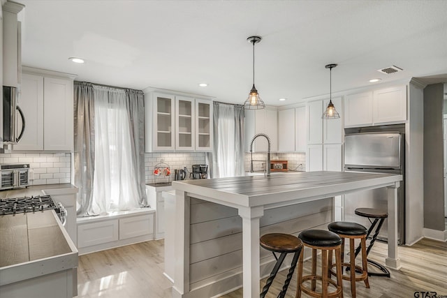 kitchen featuring light hardwood / wood-style floors, white cabinetry, and fridge