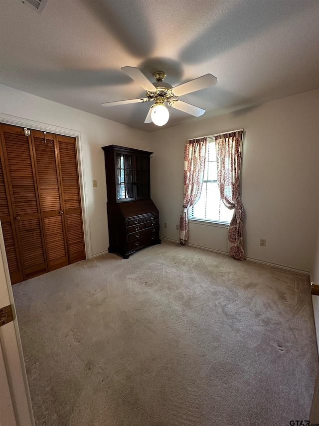 811 Windmill Ln, Athens, TX 75751 - unfurnished bedroom featuring carpet floors, a ceiling fan, a closet, baseboards, and a textured ceiling