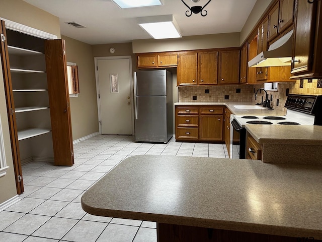 811 Windmill Ln, Athens, TX 75751 - kitchen featuring white electric range, freestanding refrigerator, a sink, under cabinet range hood, and decorative backsplash