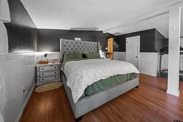 110 Utah St, Van, TX 75790 - bedroom with a wainscoted wall, wood finished floors, a textured ceiling, and vaulted ceiling