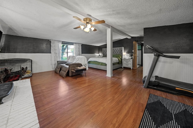 110 Utah St, Van, TX 75790 - bedroom with wood finished floors, wainscoting, a textured ceiling, and ceiling fan