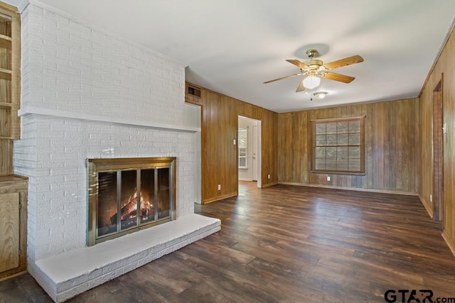 1209 E 8th St, Tyler, TX 75701 - unfurnished living room with ceiling fan, wood walls, wood finished floors, and a brick fireplace