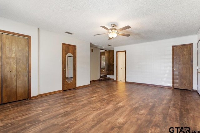 1209 E 8th St, Tyler, TX 75701 - unfurnished bedroom with wood finished floors, a textured ceiling, ceiling fan, and two closets