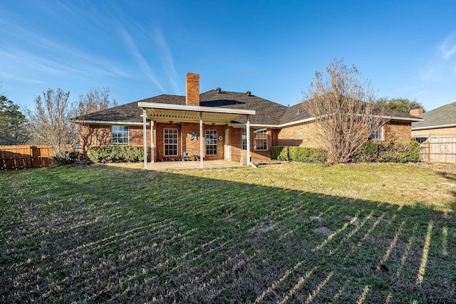 back of property featuring brick siding, a chimney, a patio area, and fence