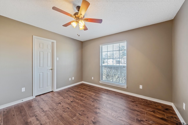 unfurnished room with dark wood-style flooring, a textured ceiling, and baseboards