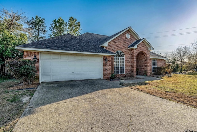 traditional home with a front yard, brick siding, driveway, and an attached garage