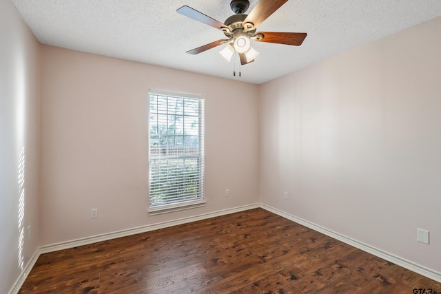 spare room featuring dark wood-style flooring, ceiling fan, a textured ceiling, and baseboards