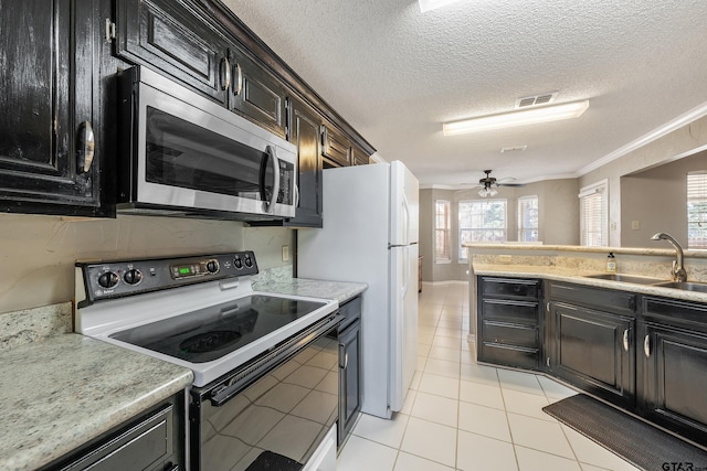 kitchen with electric range, a sink, visible vents, light countertops, and stainless steel microwave