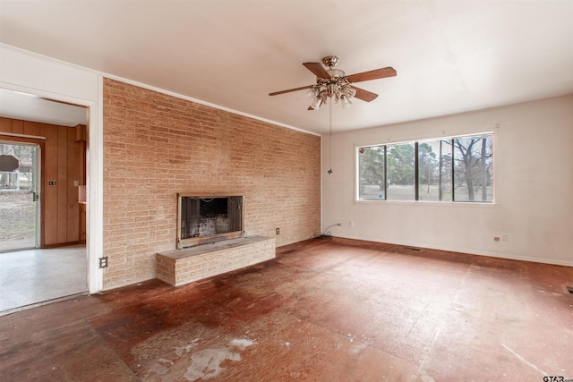 unfurnished living room with a ceiling fan, baseboards, a fireplace, and brick wall