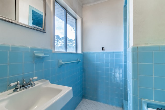 bathroom featuring tile walls, a sink, and wainscoting