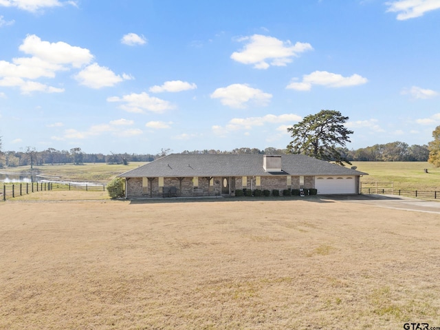 view of front of home with a garage and a rural view