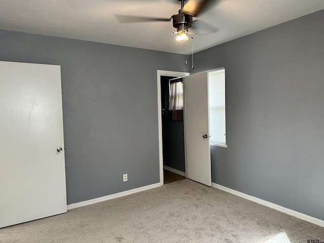 unfurnished bedroom with ceiling fan and light colored carpet