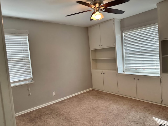 unfurnished room with ceiling fan and light colored carpet