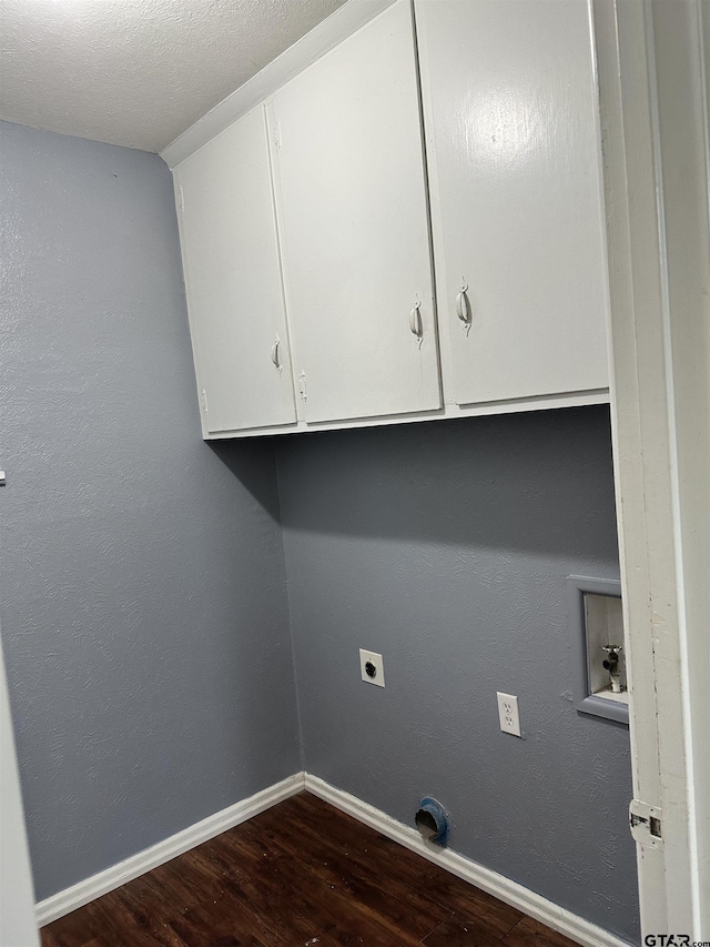 laundry area featuring hardwood / wood-style floors, hookup for an electric dryer, washer hookup, a textured ceiling, and cabinets