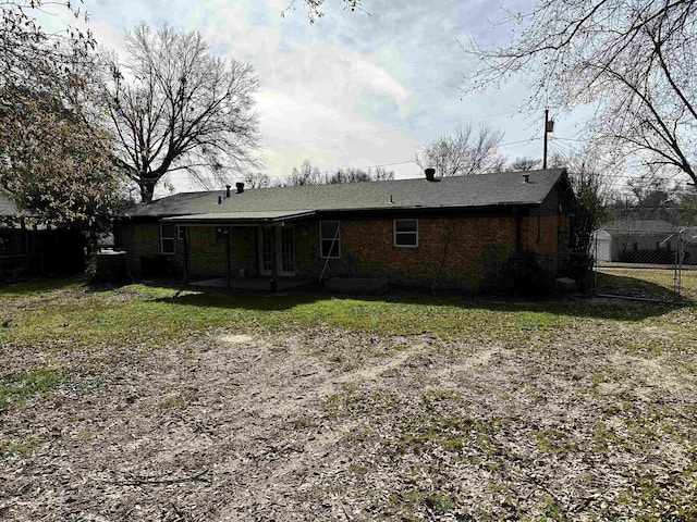 rear view of house featuring a lawn