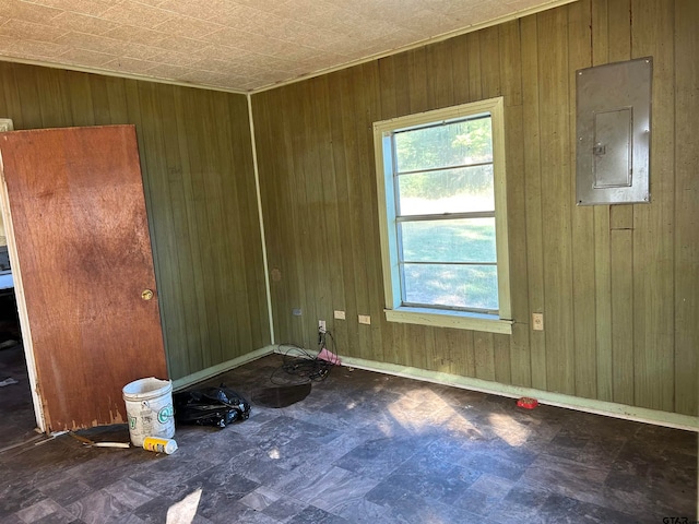 spare room with electric panel and wooden walls