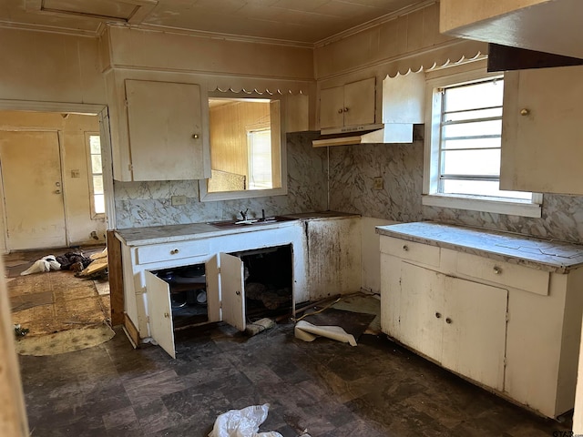 kitchen featuring decorative backsplash, cream cabinetry, and crown molding