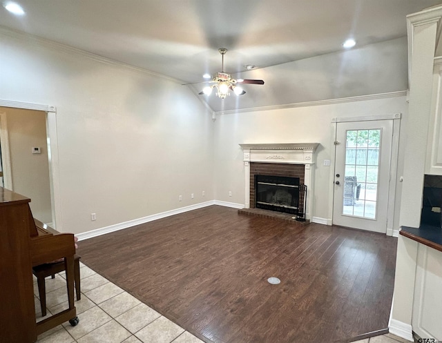 807 Brownwood Cir, Lindale, TX 75771 - unfurnished living room featuring a ceiling fan, ornamental molding, a fireplace, vaulted ceiling, and wood finished floors