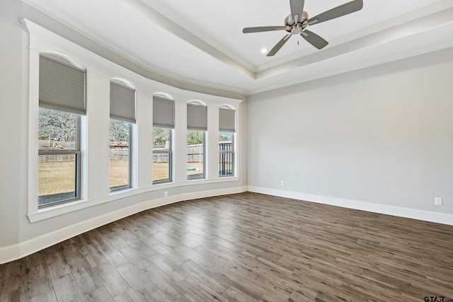 spare room with hardwood / wood-style flooring, ceiling fan, crown molding, and a raised ceiling