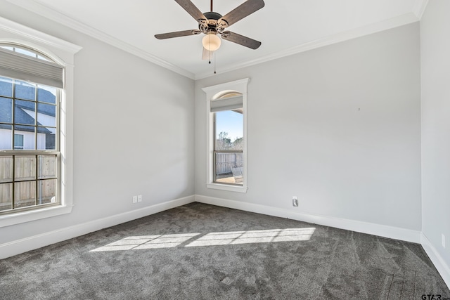 empty room with dark colored carpet, ceiling fan, and crown molding