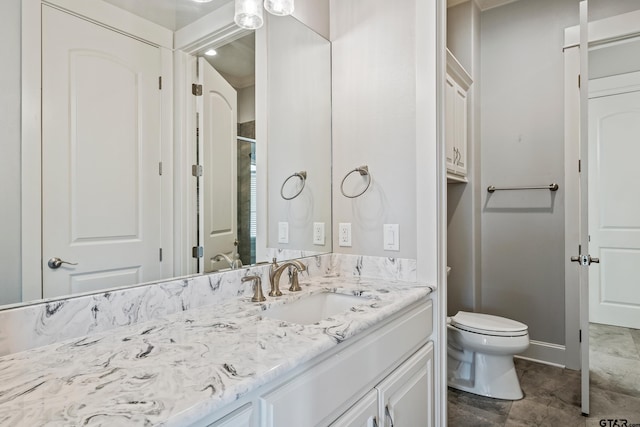 bathroom with vanity, a shower with shower door, and toilet