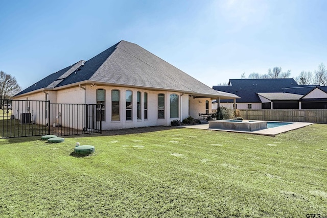 back of house with central AC unit, a fenced in pool, a patio area, and a lawn