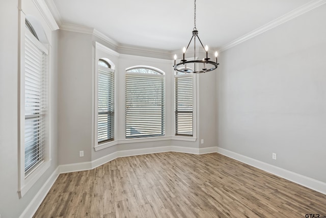 unfurnished dining area with crown molding, a notable chandelier, and light wood-type flooring